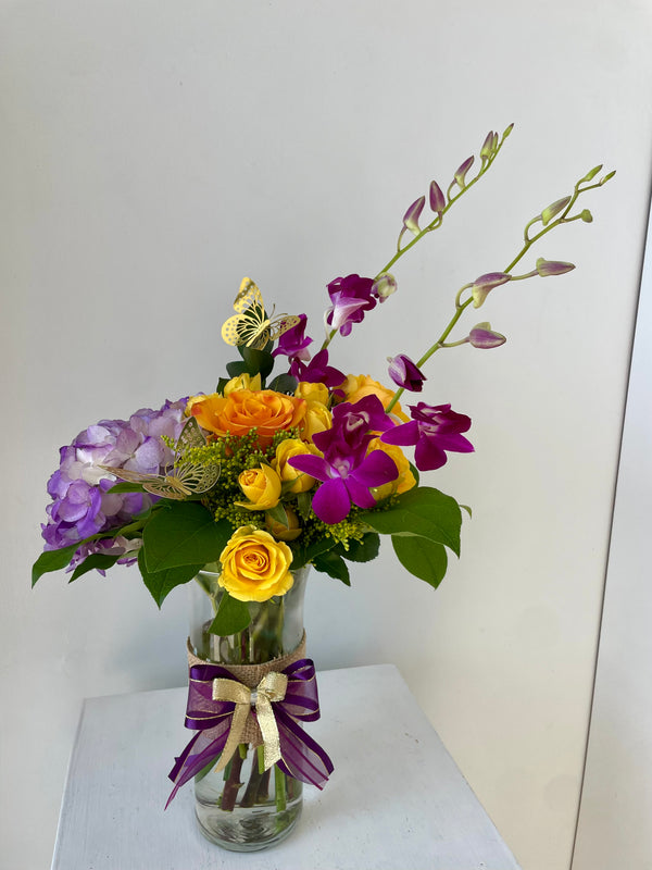 Arrangement with hydrangeas, 6 roses, and dendrobium orchids in a vase