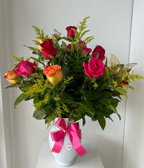 Classic bouquet of 12 roses in assorted colors with greenery in a glass vase